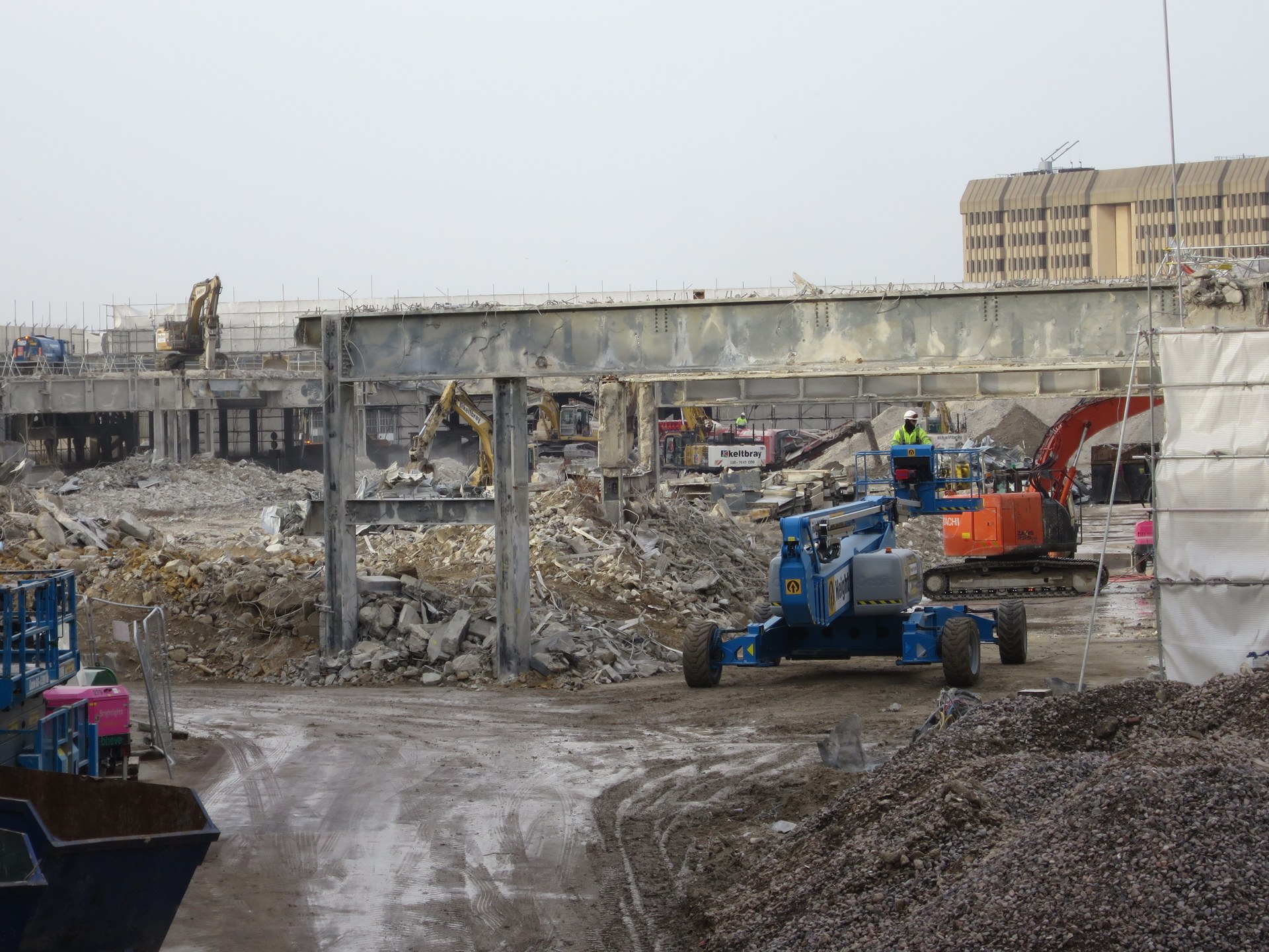 Demolition works at Earls Court Two, London, with exposed concrete structure and cleared building materials